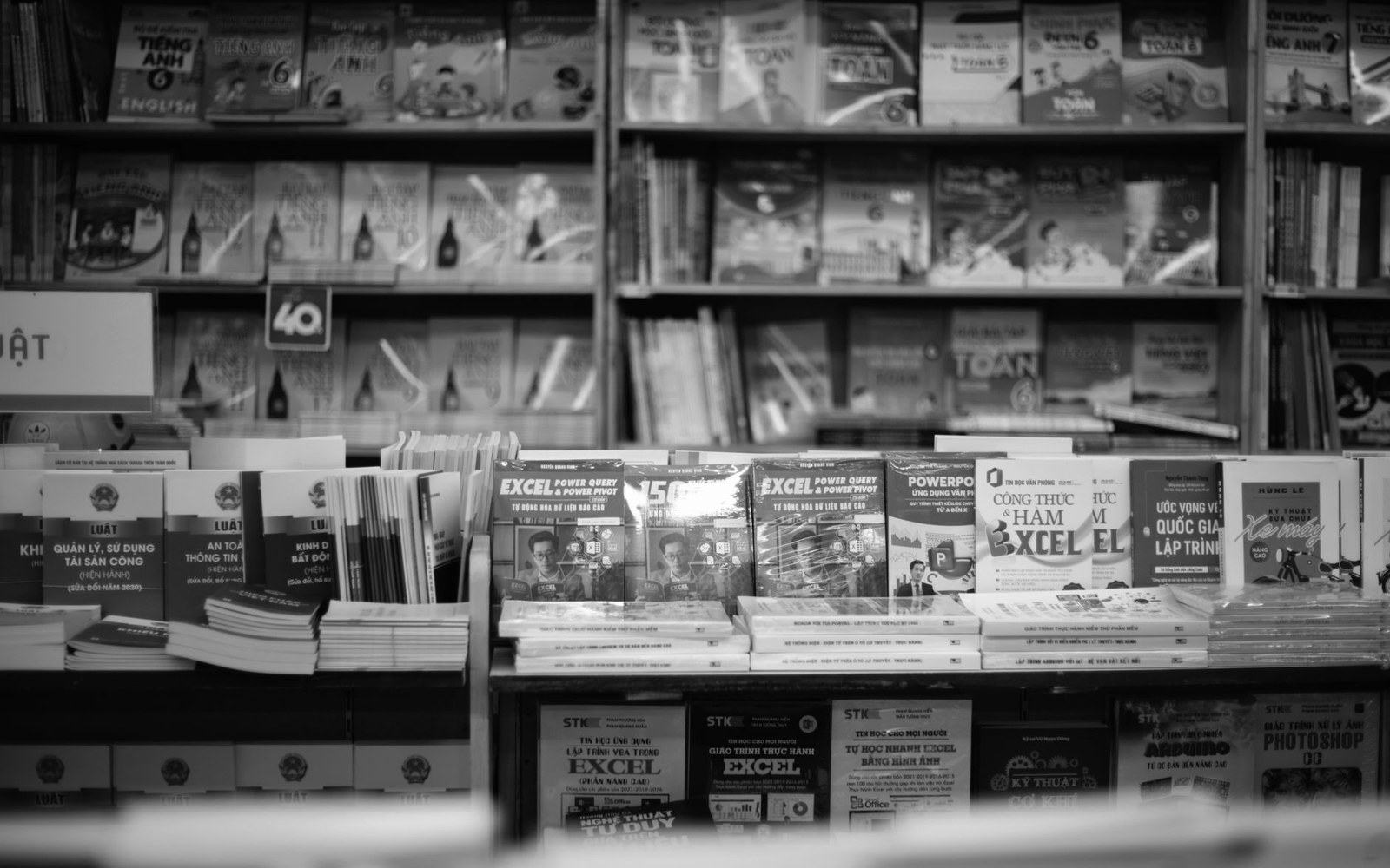 Shelves and stacks of Vietnamese-language textbooks and computer manuals displayed in a bookstore