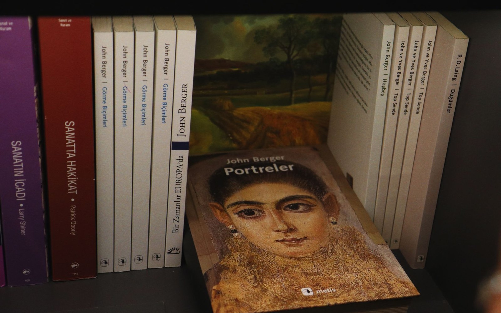 A close shot of a shrink-wrapped Russian paperback with a printed warning label visible through the plastic, on a bookshop shelf